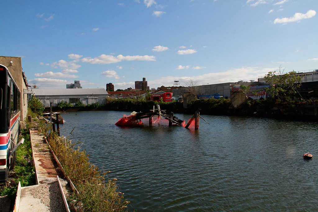 Una toma general del muelle hundido con la intervención artística. El muelle está en medio del Canal Gowanus en Brooklyn, Nueva York.