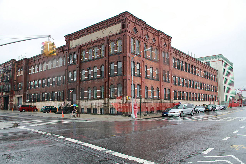 The orange fencing wraps arround the block of the Can factory building where the project was shown